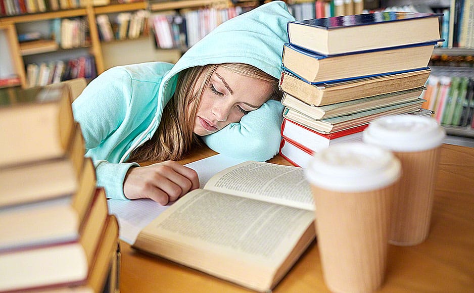 student or woman with books sleeping in library