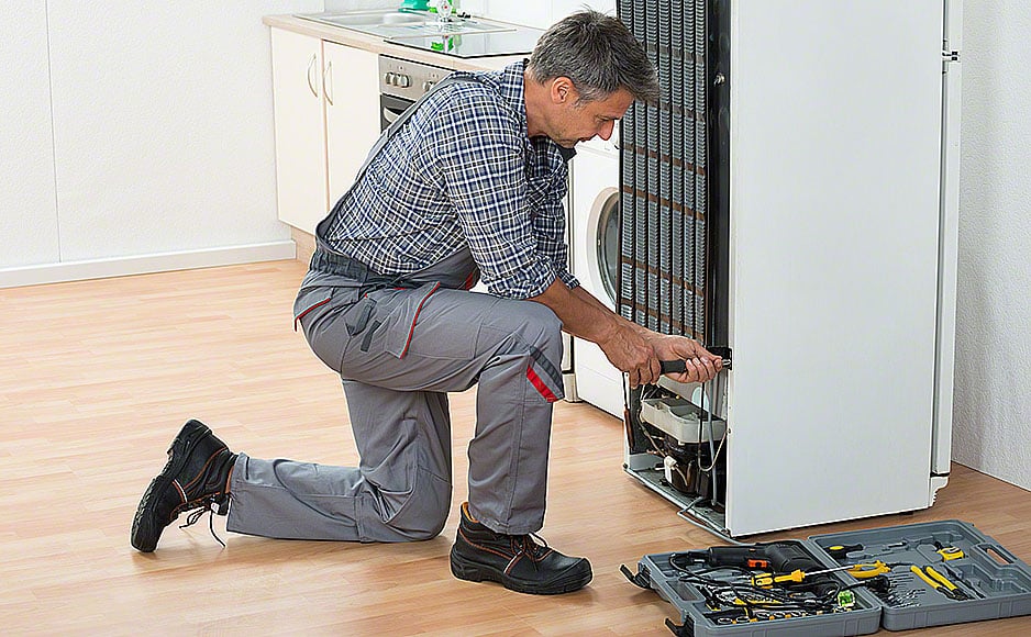 Handyman Repairing Refrigerator At Home