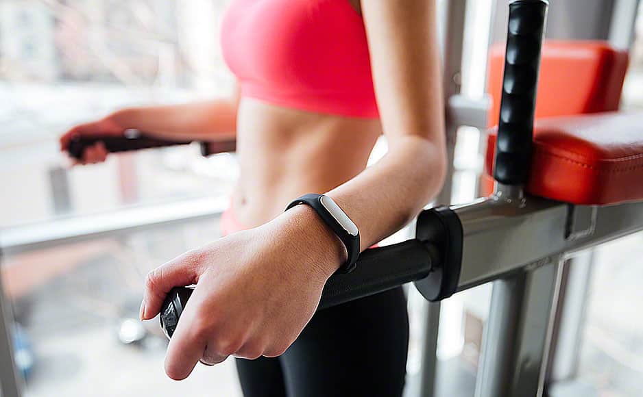 Woman athlete with fitness tracker on hand working out