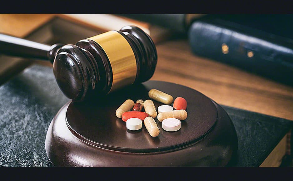 Judge gavel and drugs on a wooden desk