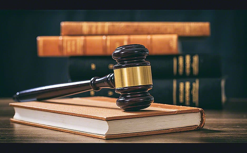 Judge gavel on a book, law books background, wooden desk