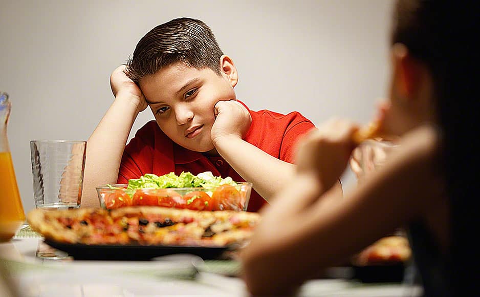 Mother Giving Salad Instead Of Pizza To Overweight Son
