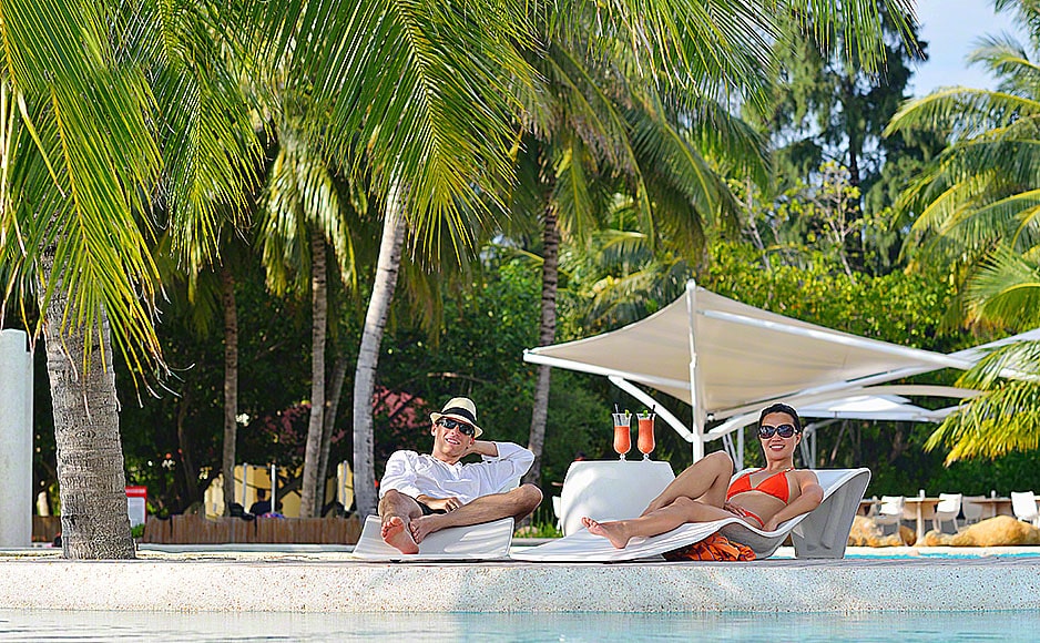 happy young couple relax and take fresh drink on poolside