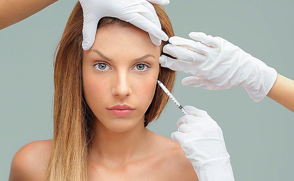 young woman with doctor hands injecting botox